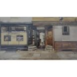 Phyllis Dimond- A framed and glazed print of a shop front, printed signature. H.32 W.41.5cm