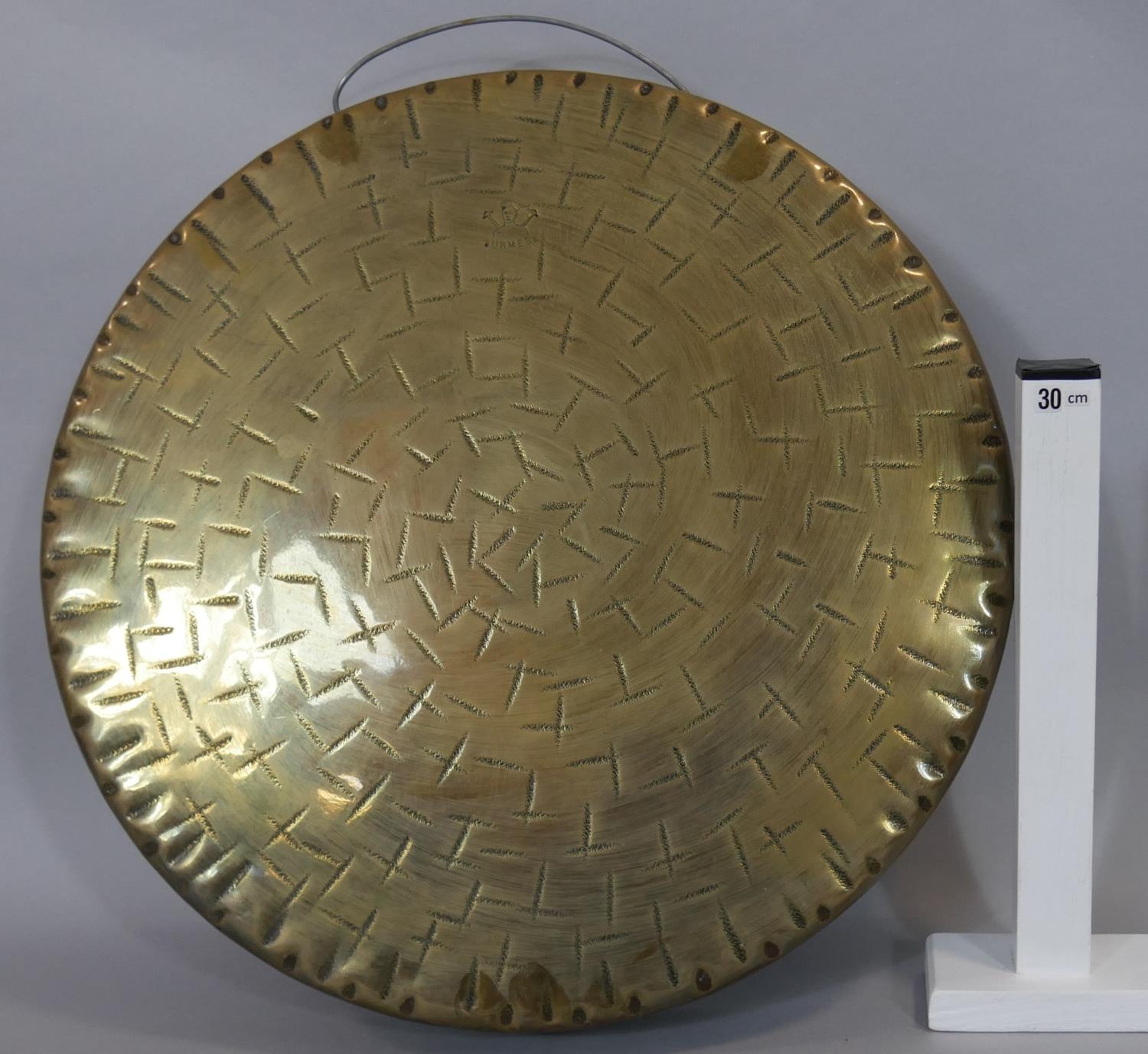 A large oriental hammered brass gong with carrying handle. D.45cm