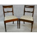 A pair of late Georgian mahogany dining chairs with carved bar backs and splats above drop in