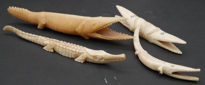 A collection of four carved bone crocodile figures. L.20cm