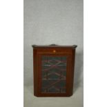 A 19th century mahogany hanging corner cabinet with satinwood starburst inlay and astragal glazed