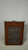 A 19th century mahogany hanging corner cabinet with satinwood starburst inlay and astragal glazed