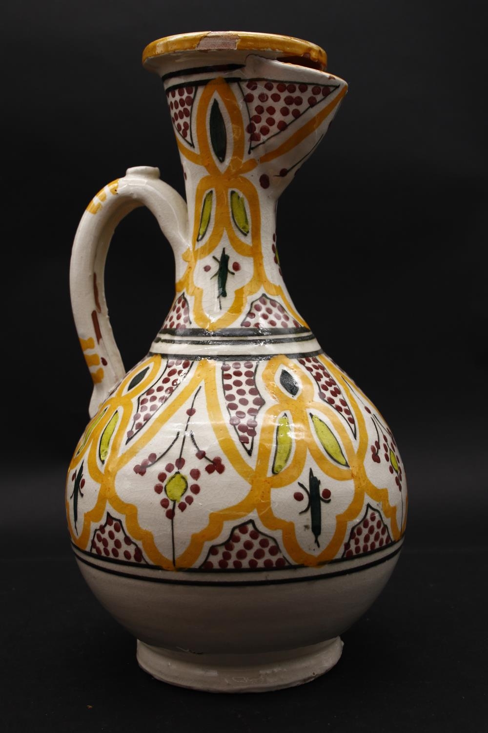 An Islamic glazed hand painted terracotta ewer with stylised foliate and floral design with two - Image 2 of 6