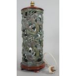 A pierced bronze Chinese lamp with scrolling dragon motifs and lacquered wooden top and base. H.54cm