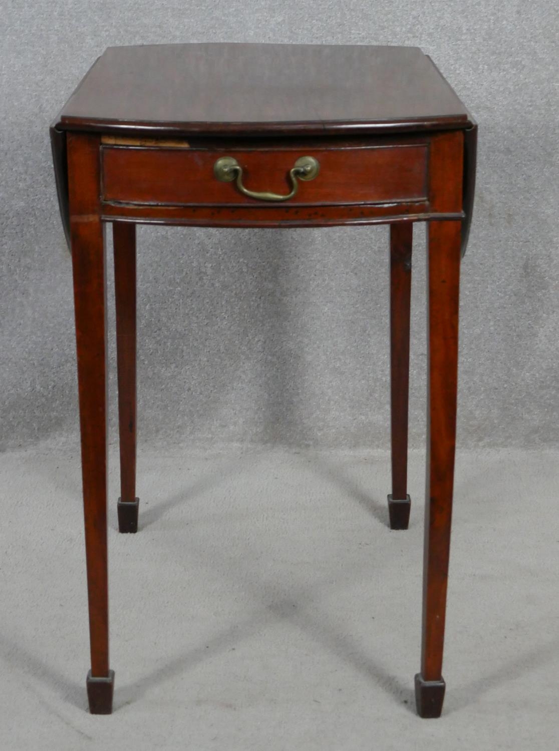 A 19th century mahogany Pembroke table with ebony and satinwood stringing raised on slender square