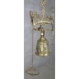 A 20th century French brass gothic style wall mounted bell with relief foliate and figural