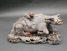 A Chinese carved rosewood water buffalo with man on his back on floral design pierced hardwood