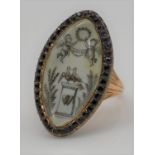 A Georgian red metal mourning ring, the navette-shaped ivory panel painted en grisaille to depict
