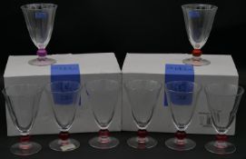 Three sets of Studio Nova drinking glasses, each with different coloured ball stem, one with red,