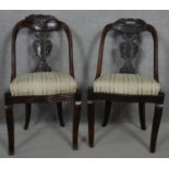 A pair of late 19th century Continental mahogany hooped back dining chairs with carved splats on