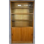 A mid century vintage teak library bookcase by Gibbs Furniture with sliding glazed doors enclosing