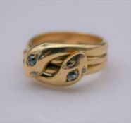 A Victorian yellow metal (tested 18ct) double headed cross over snake ring. Each of the snakes heads