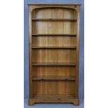 A full height floor standing pine open bookcase with arched upper section on bracket feet. H.186 W.