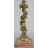 A 19th century gilt bronze candlestick the stem in the form of a cherub seated among vines raised on