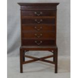 An Edwardian mahogany music cabinet fitted with five hinged fall front sheet music drawers raised on