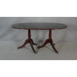 A Georgian style mahogany dining table with extra leaf on twin tripod pedestal bases. H.76 L.217 W.