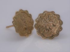 A pair of 15 carat yellow gold engraved scalloped edge stud earrings. Engraved with a floral motif