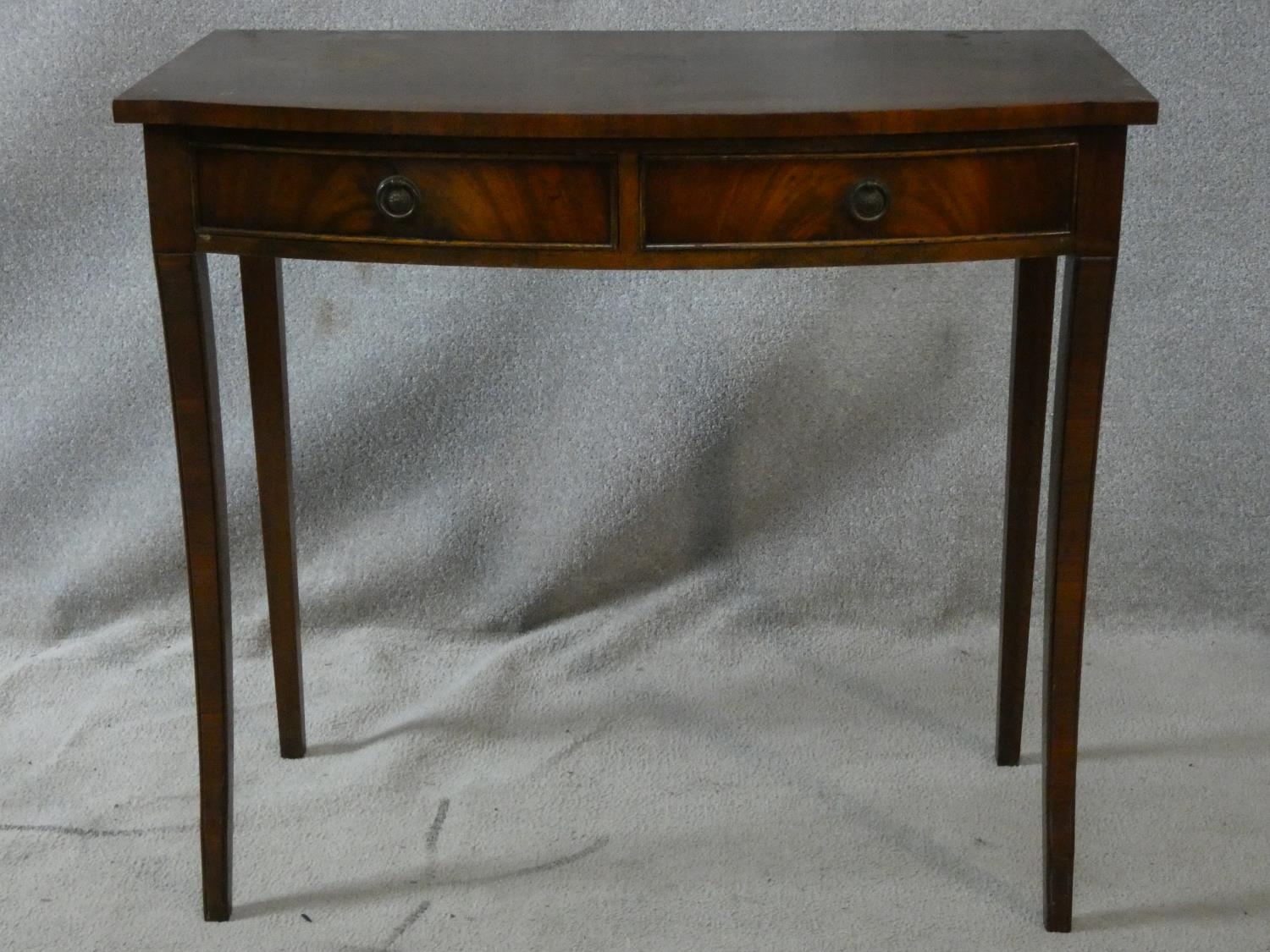 A Regency style flame mahogany console table fitted with frieze drawers on sabre supports. H.77 L.85