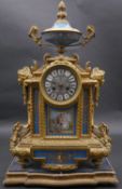 A 19th century ormolu and porcelain eight day mantel clock with urn surmount and enamel face with