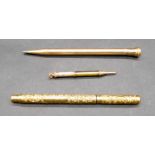 Three gold plated pens and pencils. Including a Swan engraved scrolling design rolled gold pen,