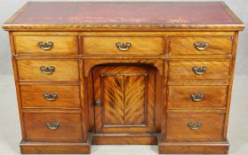 A late 19th century satin birch kneehole desk with inset tooled leather top above an arrangement
