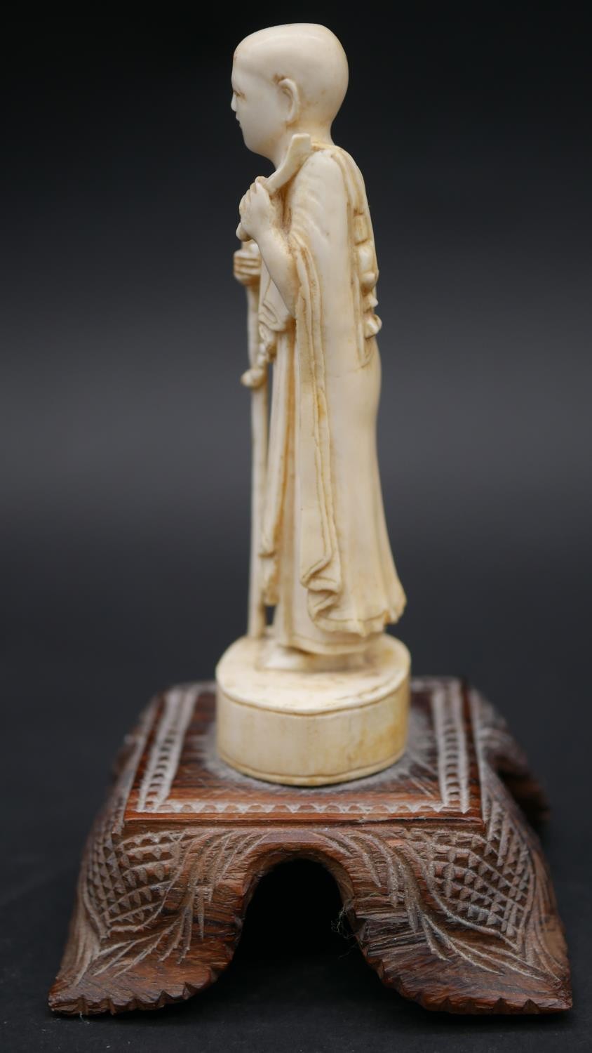 An antique carved Chinese ivory statue of a Luohan mounted on a floral form hardwood base. H.13cm - Image 4 of 11