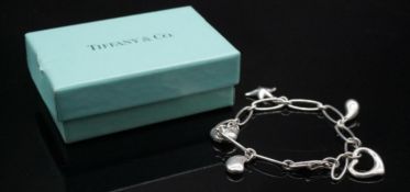 A Tiffany and Co silver Elsa Peretti charm bracelet, set with five silver charms comprising a