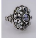 A white metal, Iolite and seed pearl antique ring, set with five oval shaped mixed iolite and