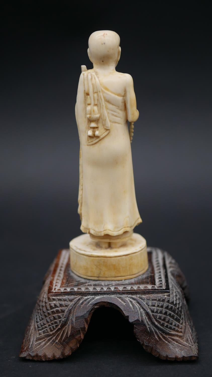 An antique carved Chinese ivory statue of a Luohan mounted on a floral form hardwood base. H.13cm - Image 3 of 11