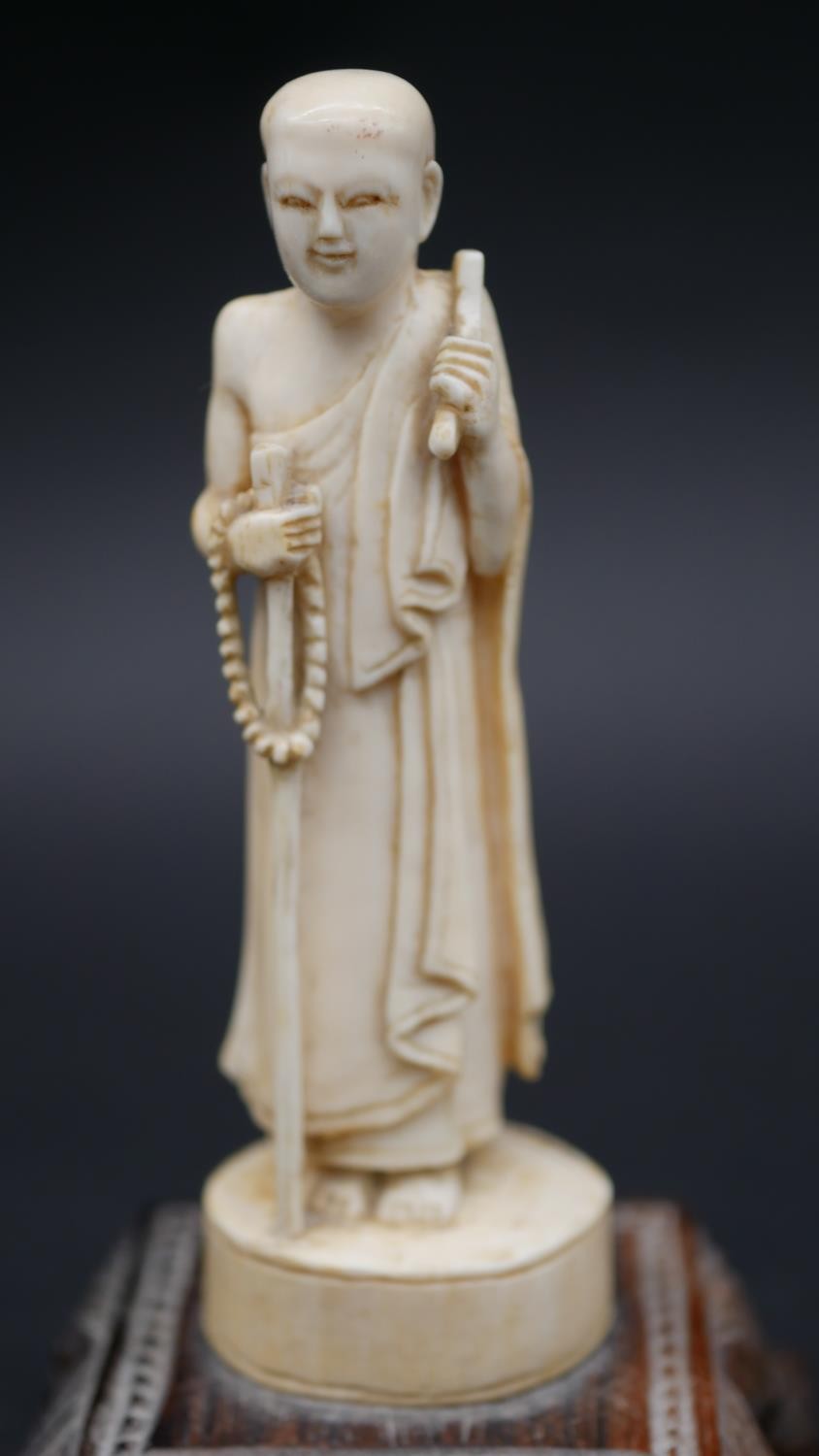 An antique carved Chinese ivory statue of a Luohan mounted on a floral form hardwood base. H.13cm - Image 5 of 11