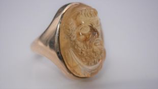 A carved citrine ring with a relief classical portrait set in a yellow metal setting with D-shape