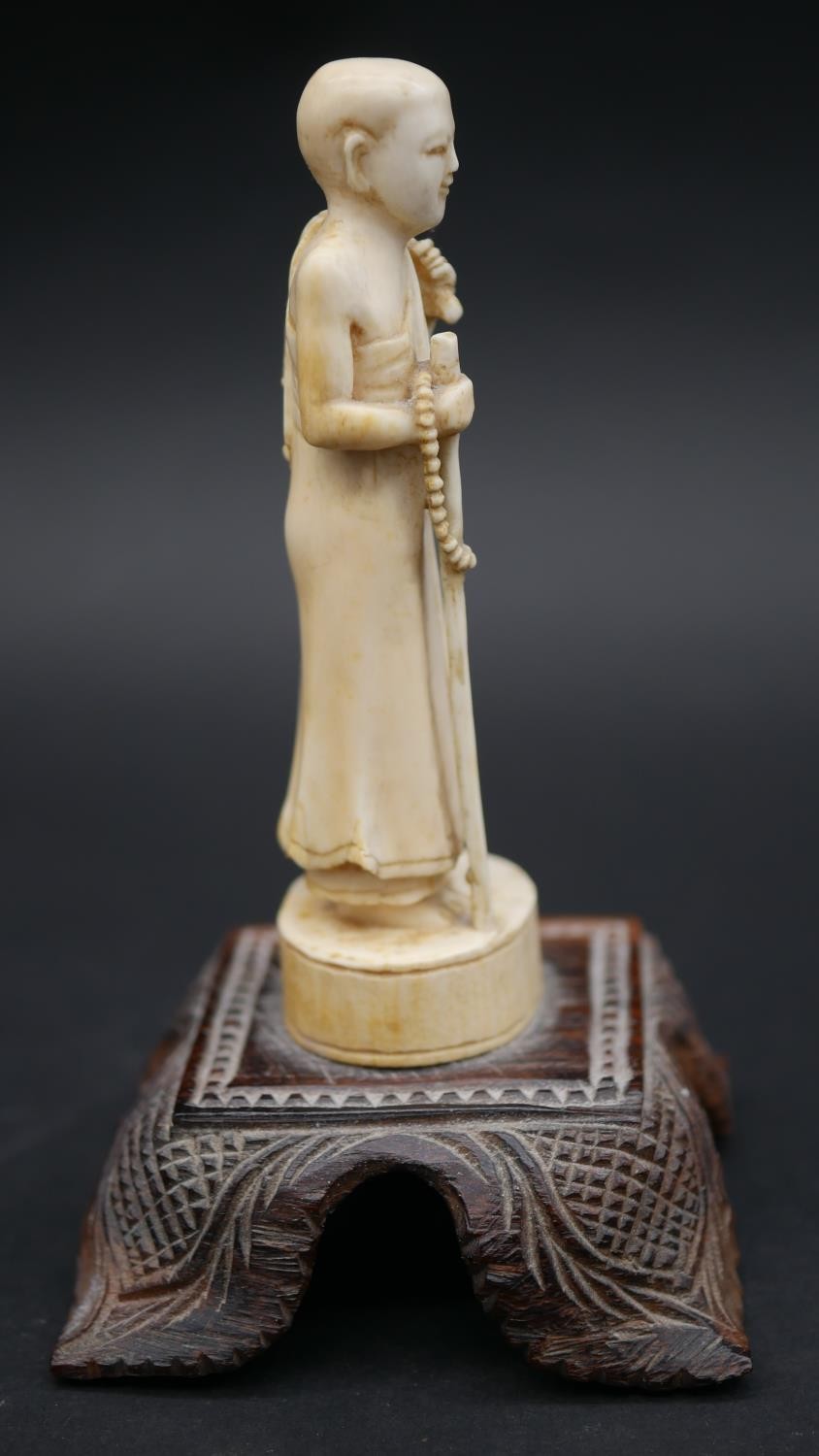 An antique carved Chinese ivory statue of a Luohan mounted on a floral form hardwood base. H.13cm - Image 2 of 11