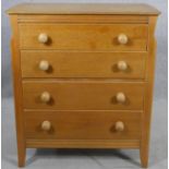 A mid century light oak chest of drawers on splay supports with maker's label to the inside. H.90