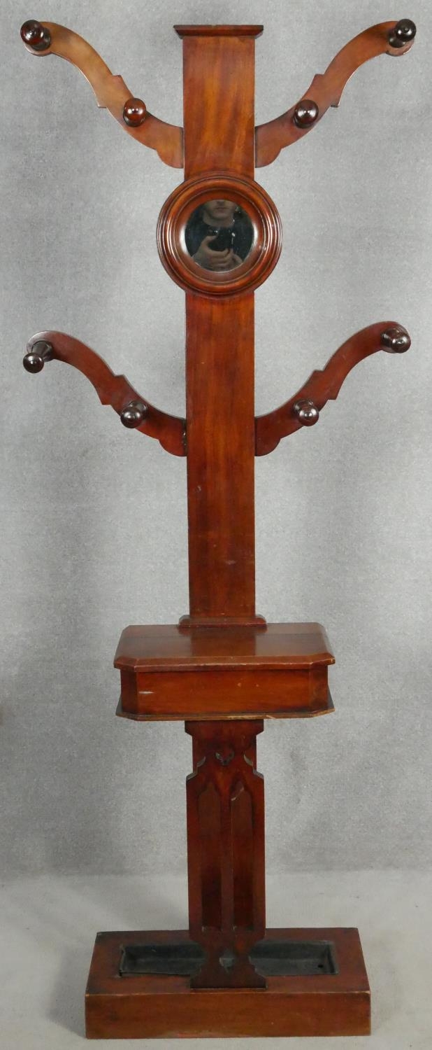 A Victorian mahogany hallstand with turned coat hooks on swept branches fitted with vanity mirror