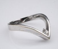 A white metal wish bone ring set with a round brilliant cut diamond in a two claw setting with an