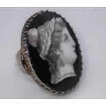A Georgian style silver ring, set with a grisaille enamel plaque on porcelain of a profile of a