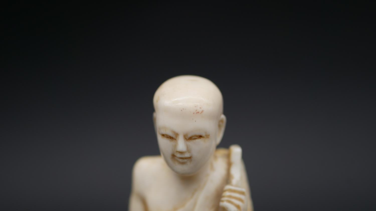 An antique carved Chinese ivory statue of a Luohan mounted on a floral form hardwood base. H.13cm - Image 9 of 11