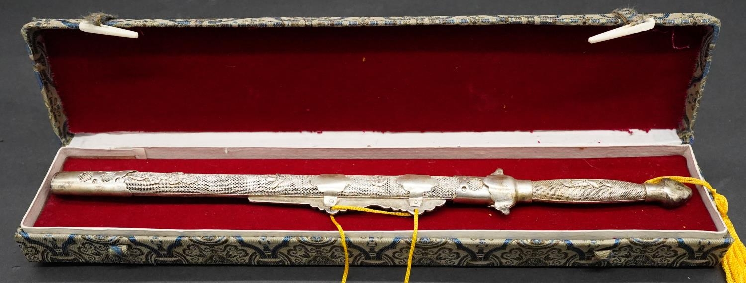 A boxed Oriental white metal letter opener with steel blade in the form of a ceremonial sword with