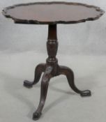 A Georgian style mahogany tilt top occasional table with pie crust edge on husk carved turned