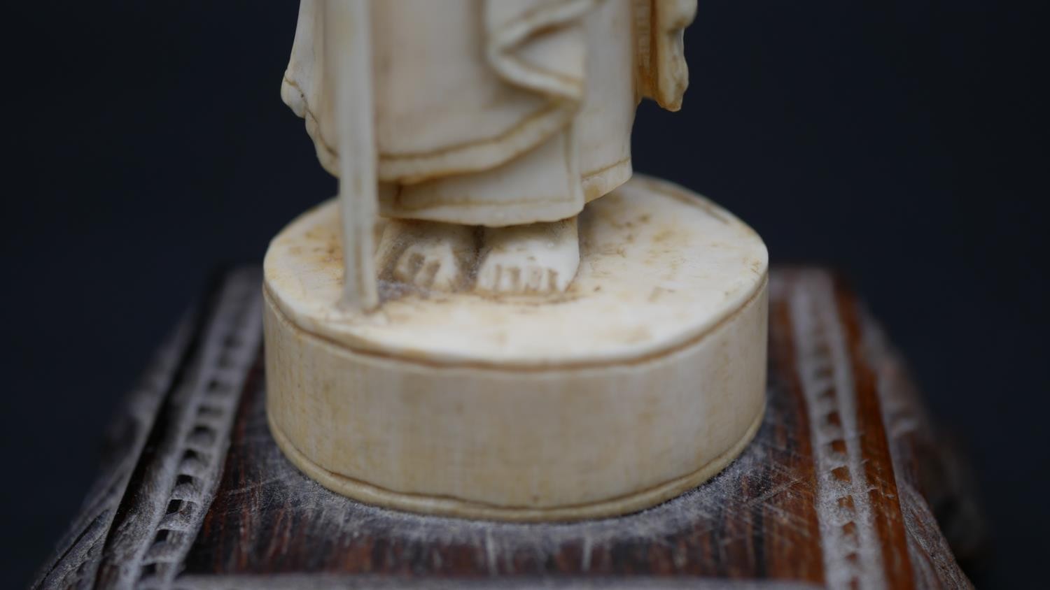 An antique carved Chinese ivory statue of a Luohan mounted on a floral form hardwood base. H.13cm - Image 8 of 11