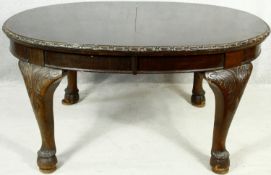 An early 20th century mahogany Georgian style dining table with extra leaf and wind out mechanism on