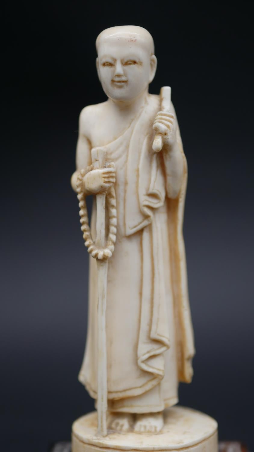 An antique carved Chinese ivory statue of a Luohan mounted on a floral form hardwood base. H.13cm - Image 6 of 11