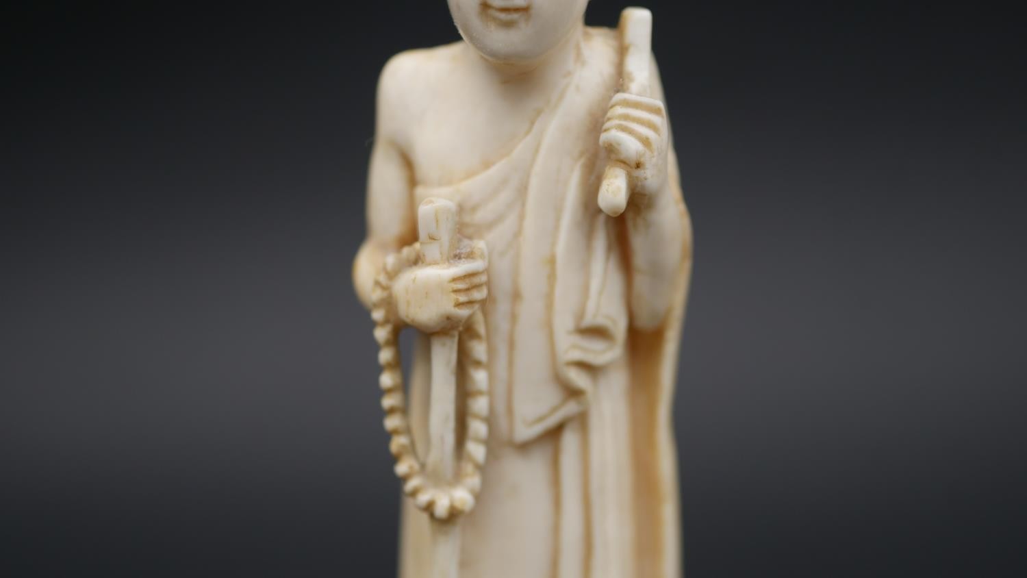 An antique carved Chinese ivory statue of a Luohan mounted on a floral form hardwood base. H.13cm - Image 10 of 11