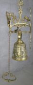 A 20th century French brass gothic style wall mounted bell with relief foliate and figural