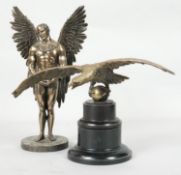 Two sculptures. One of a brass eagle in flight perched on a ball, mounted on an ebony two tier