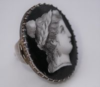 A Georgian style silver ring, set with a grisaille enamel plaque on porcelain of a profile of a