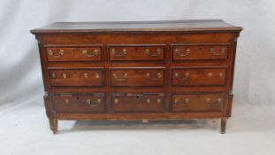 A Georgian oak and mahogany crossbanded mule chest with hinged lidded top and coffer section faced