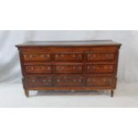 A Georgian oak and mahogany crossbanded mule chest with hinged lidded top and coffer section faced