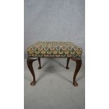 A mid century Georgian style mahogany stool in tapestry upholstery on cabriole supports. H.49 W.55