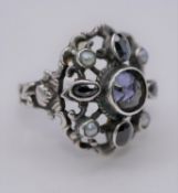 A white metal, Iolite and seed pearl antique ring, set with five oval shaped mixed iolite and